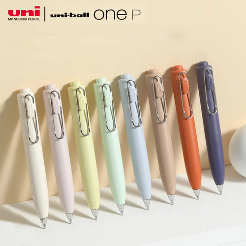 A variety of Uni-Ball One P - Pocket Pens in Various Colours are lined up on a table.