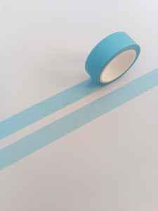 A roll of light blue and white grid washi tape on a white background