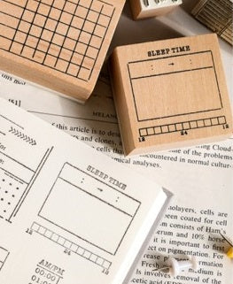 A set of GretelCreates Sleep Tracker Journal Stamps on Wooden Blocks with a book on top of them.