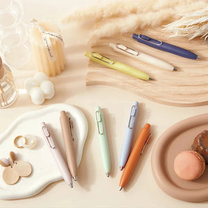 A variety of uni-ball Uni-Ball One P - Pocket Pens in Various Colours and other items on a table.