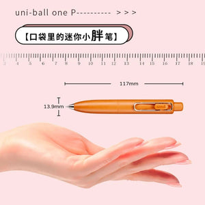 A person's hand with a ruler and a Uni-Ball One P - Pocket Pen in Various Colours. (uni-ball)