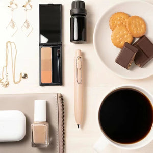 A white table with Uni-Ball One P - Pocket Pen in Various Colours and coffee on it.