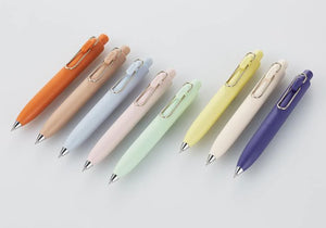 Five Uni-Ball One P - Pocket Pens in Various Colours are lined up on a white surface.