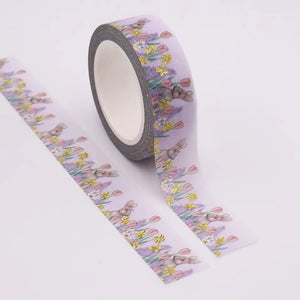 A roll of Gold Foil Spring Bunny Washi Tape with Spring Daffodils & Tulips Decorative Tape on it by GretelCreates.