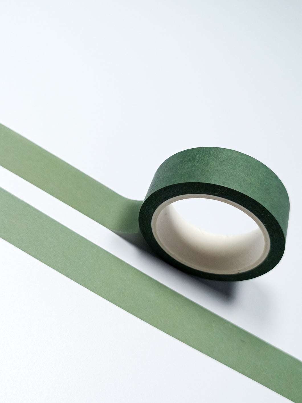 A roll of Minimal Dark Olive Green Plain Washi Tape by GretelCreates on a white surface.