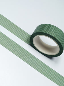 A roll of Dark Olive Green & White Grid GretelCreates Washi Tape on a white surface.